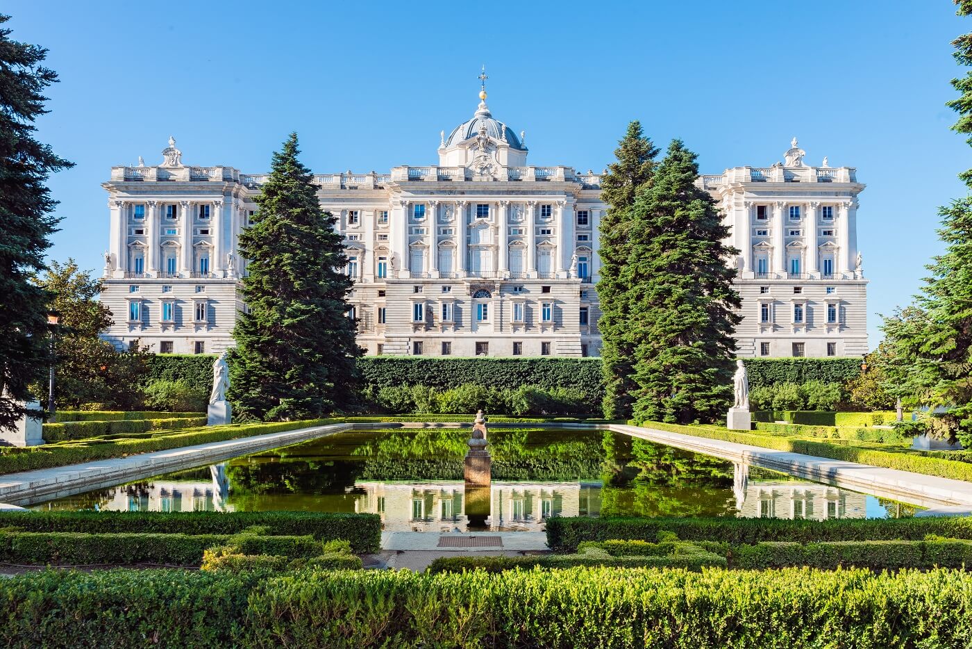 Das Palacio Real in der Spaniens Hauptstadt Madrid und grüner Garten mit Bäumen