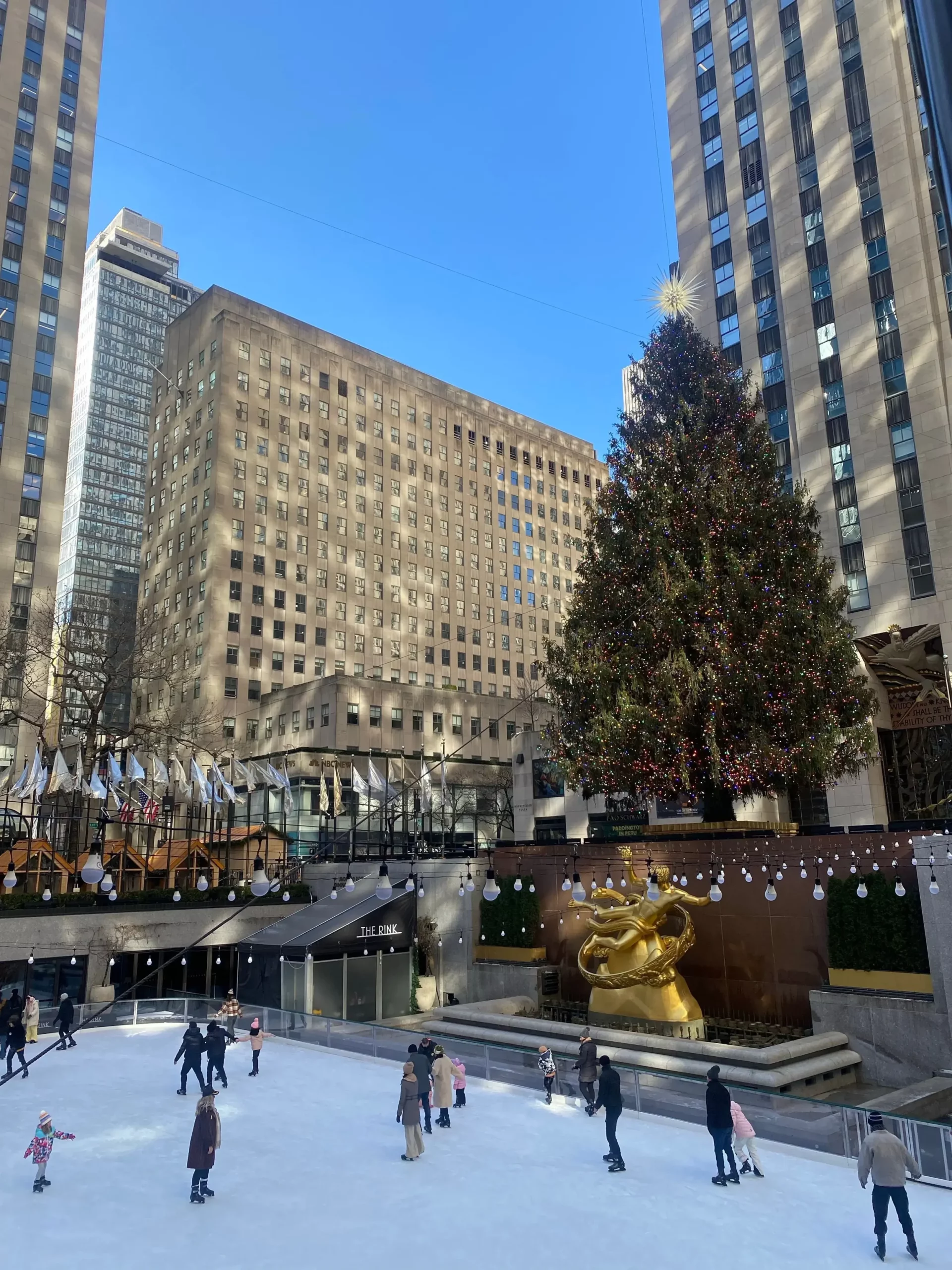 Großer geschmückter Weihnachtsbaum am Rockefeller Center neben der Eislaufbahn in New York